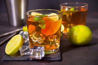 Taze Küba kokteyli ya da siyah arka planda kahverengi rom, kola, nane ve limonlu viski kola kokteyli. Long Island Buzlu Çay Kokteyli.