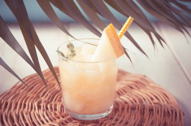 Tropikal temalı palmiye yaprağının altında kavun kokteyli.