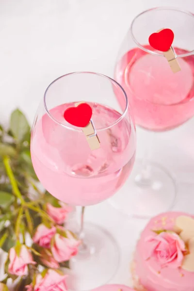 Dwie Szklanki Różowego Wina Winogronowego Przypinką Kształcie Serca Róże Tle — Zdjęcie stockowe