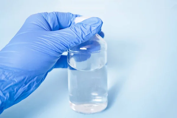 Medico Guanti Lattice Blu Con Una Bottiglia Con Medicina Liquida — Foto Stock