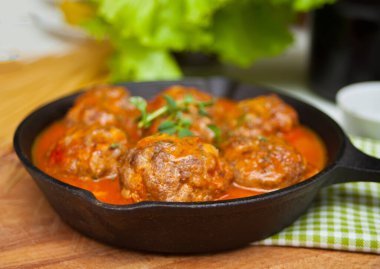 Baharatlı domates soslu köfte ve demir tavada otlar..