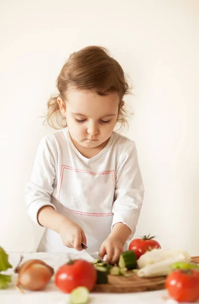 Мила кучерява дівчина готує овочі для салату на домашній кухні. Здорове харчування . — стокове фото
