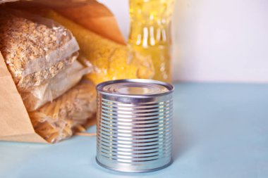 Masada çeşitli konserve yiyecekler ve mısır gevrekleri var. Yiyecek bağışları. Yemek servisi. Üst görünüm.