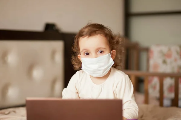 의료용 마스크를 침대에 앉아서 디지탈 태블릿 노트북 노트북 노트북을 사용하는 — 스톡 사진