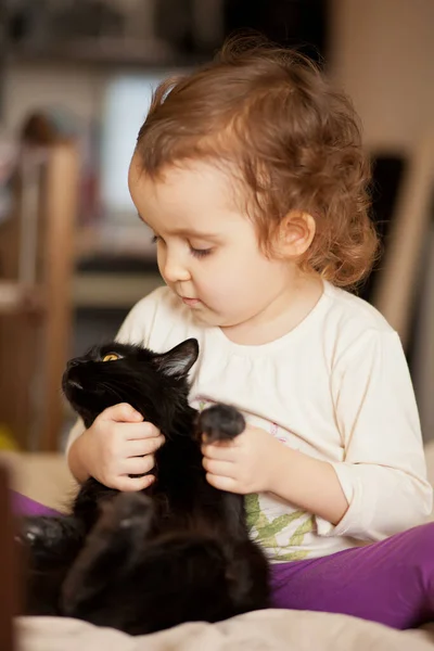 Kleine Süße Lockige Mädchen Hält Eine Schwarze Katze Der Hand — Stockfoto