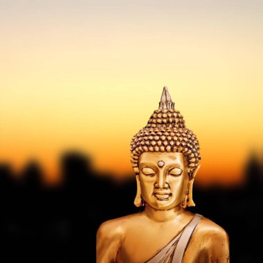Altın günbatımı arka planında Bronz Zen Buda Heykeli