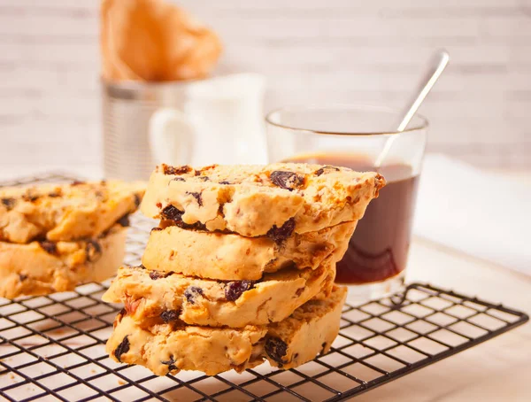 Italian biscotti on the baking rack and glass of coffee on the background.