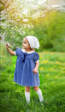 Çiçek açan bir bahçede küçük bir kız. Retro vintage moda