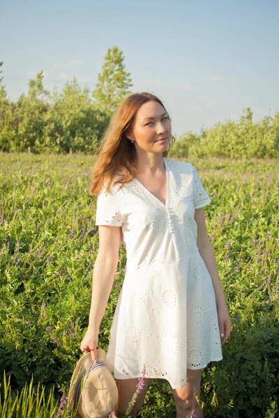 Young Woman White Dress Meadow She Stands Hat Her Hands — Stock Photo, Image