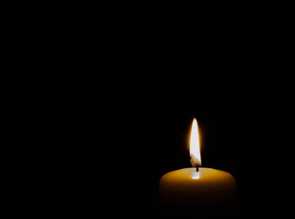 burning candle isolated on black. backgrounds and textures
