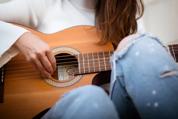 Detail of a singer girl playing the guitar