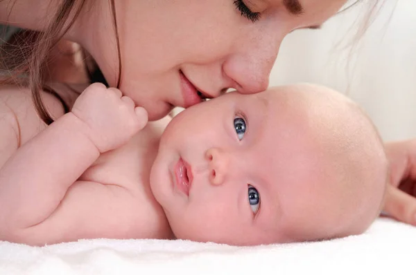 Portret van schattige kleine baby en haar moeder haar kussen — Stockfoto