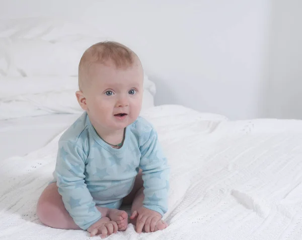 ベッドの上に座っているかわいい幸せな赤ちゃん男の子の Babyportrait — ストック写真