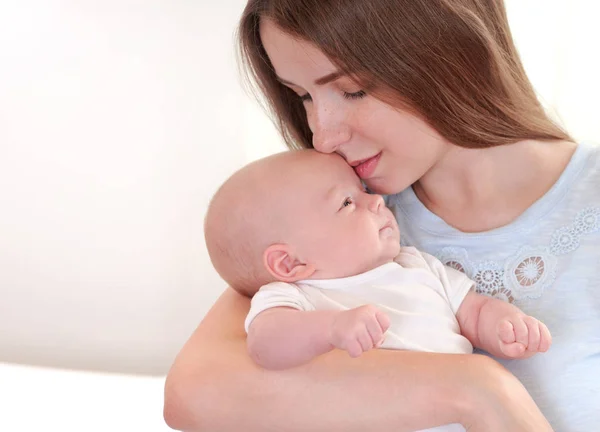 Retrato de bebê pequeno bonito e sua mãe beijando-a — Fotografia de Stock
