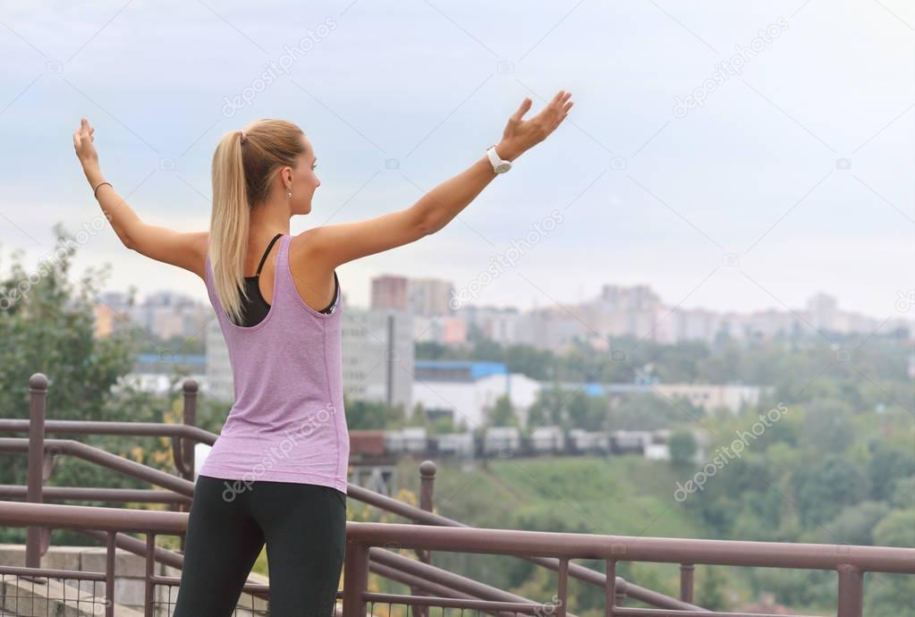 Joyful woman breathing fresh air outdoors