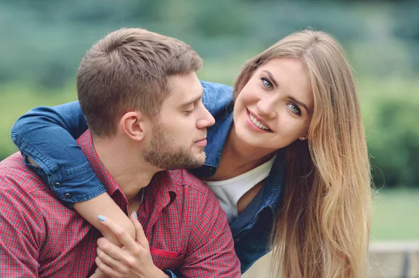 Romantikus pár ül a padon, átölelve hoznak, és mosolyogva — Stock Fotó