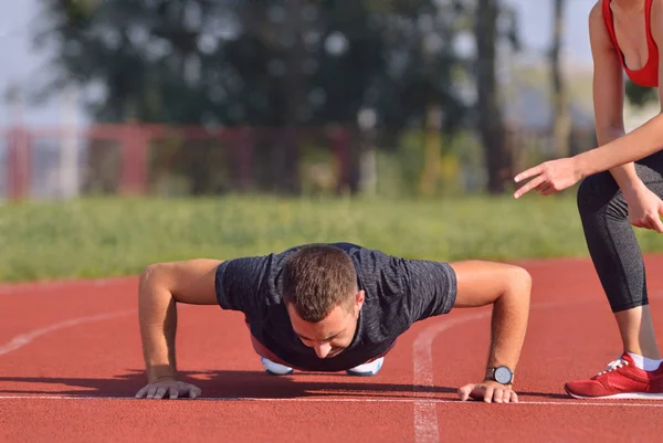 Αθλητικός άνδρας κάνει push-ups κατά τη διάρκεια της προπόνηση προπόνηση σε εξωτερικούς χώρους σταυρό. — Φωτογραφία Αρχείου