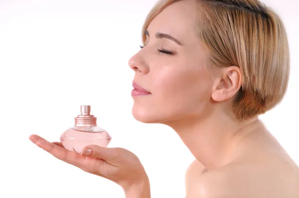 Jovem mulher adulta desfrutando o cheiro de um perfume florido — Fotografia de Stock