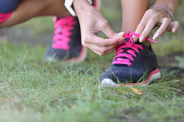 Vrouw verbindt schoenveters op sneakers — Stockfoto