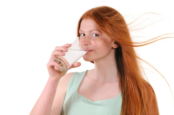 Rødt hår teenage pige drikker vand med glas - Stock-foto