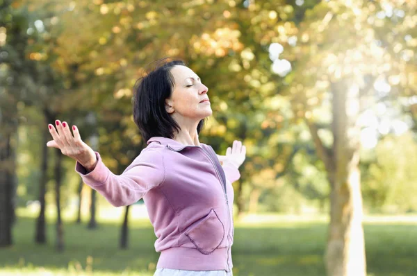 Mature woman runner taking a rest after running in the park — Stock Photo, Image