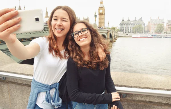 Happy smiling pretty teenage girls taking selfie at Big Ben, London — Stock Photo, Image