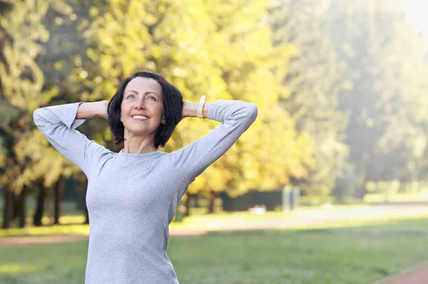 Portrait of mature woman before or after jog in the park — Stock Photo, Image