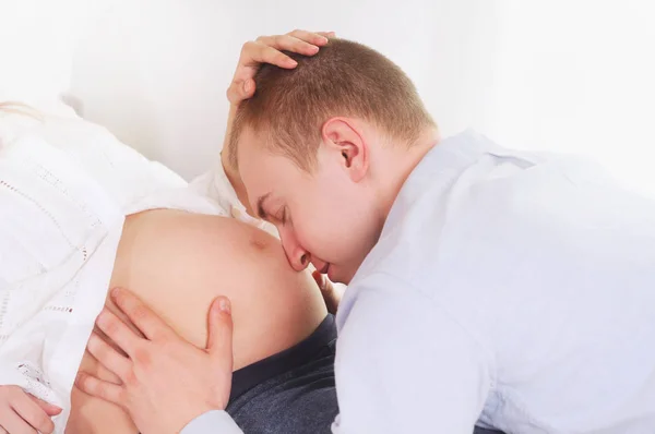 Man embraces and kisses a stomach of the pregnant woman — Stock Photo, Image
