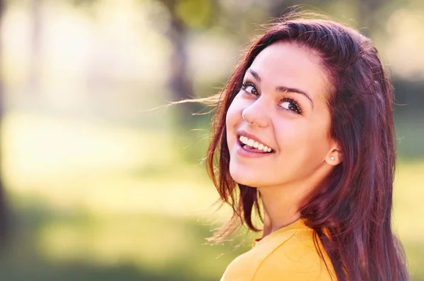 Portrait of smiling beautiful young woman against summer green park. — Stock Photo, Image