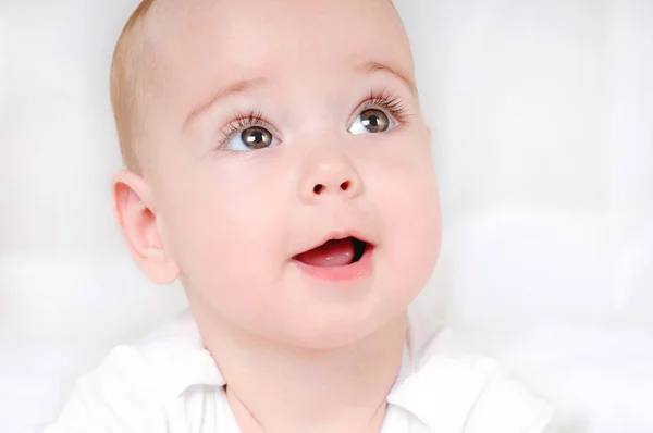 Criança sorridente feliz com olhos castanhos abertos largos — Fotografia de Stock