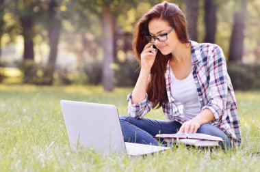 Öğrenci kız parkta çim üzerinde oturan laptop, çalışma