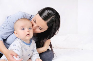 Anne ve çocuk beyaz bir yatakta