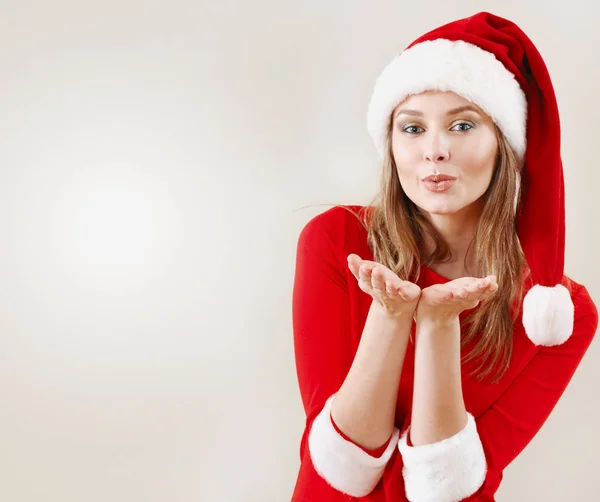 Mujer de Navidad con un sombrero de santa soplando un beso —  Fotos de Stock