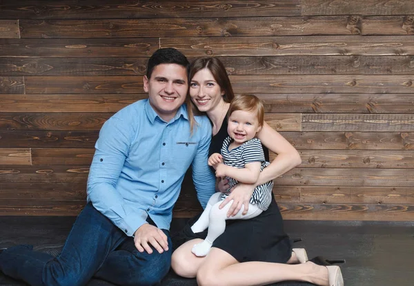 Lycklig familj sitter på golvet med sin lilla bebis — Stockfoto