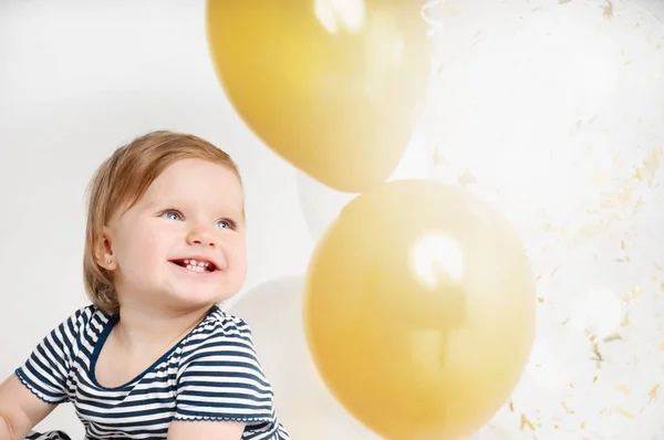 Счастливый и улыбающийся портрет годовалого ребенка на фоне воздушных шаров — стоковое фото