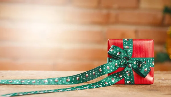 Closeup of a red gift box on blurred bricks on background — Stock Photo, Image