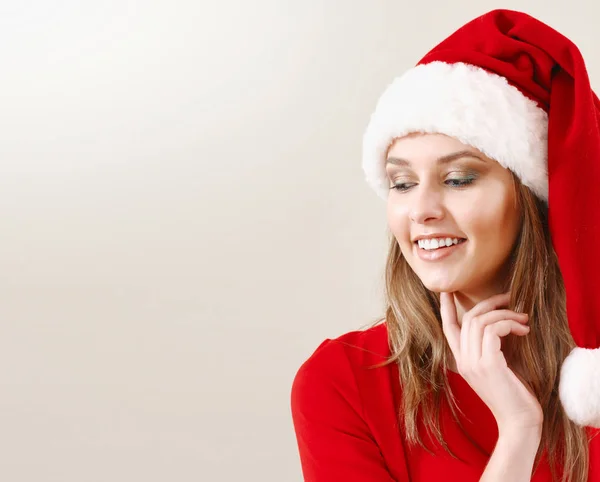 Söt ung kvinna i Santa hatt drömmer om julklappar Royaltyfria Stockbilder