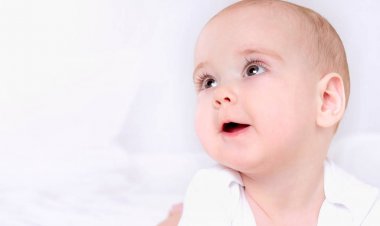 Geniş açık kahverengi gözlü mutlu gülümseyen çocuğun