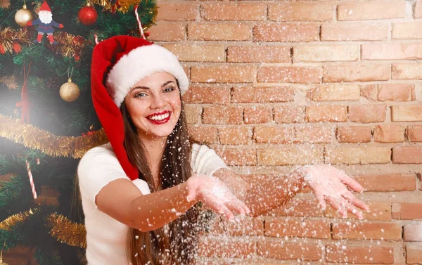 Uśmiechnięta kobieta w santa hat z show w jej ręce — Zdjęcie stockowe