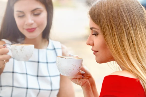 Привлекательные молодые женщины пьют кофе в летнем городе — стоковое фото