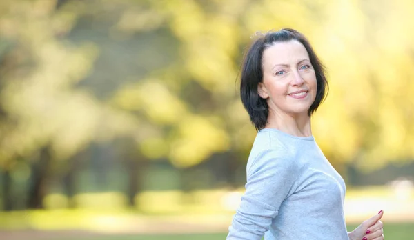 Portrait of mature woman weared in sports clothes in the park — Stock Photo, Image