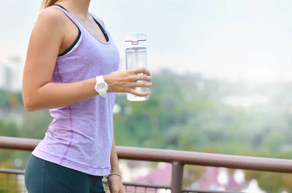 Спортивна жінка п'є воду після бігу в парку — стокове фото