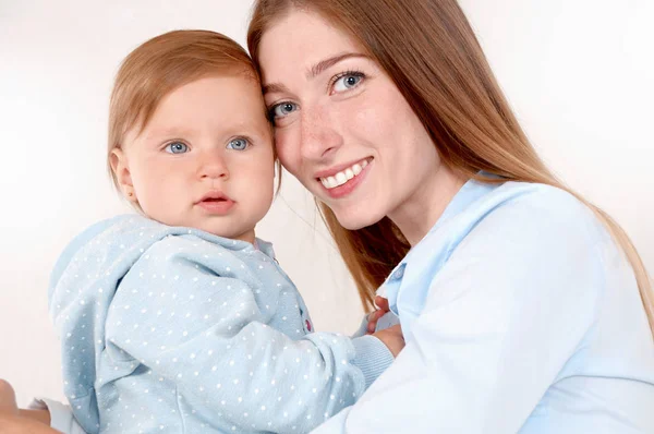 Porträt der schönen Mutter und ihres Babys im Schlafzimmer — Stockfoto