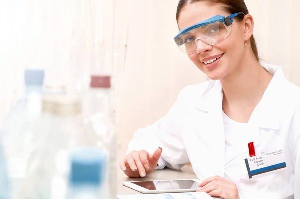 Junge Wissenschaftlerin mit Tablet-Pad schreibt Datenforschung im klinischen Labor — Stockfoto