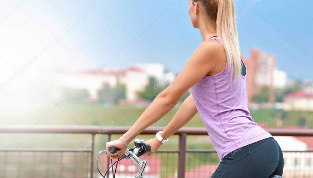 Young female biker on her bike in a city. Healthy lifestyle concept.
