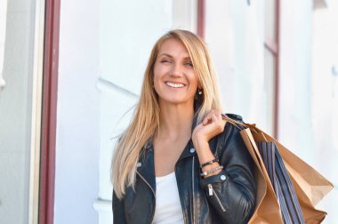 Portre genç sevimli uzun saçlı kadın alışveriş torbaları holding