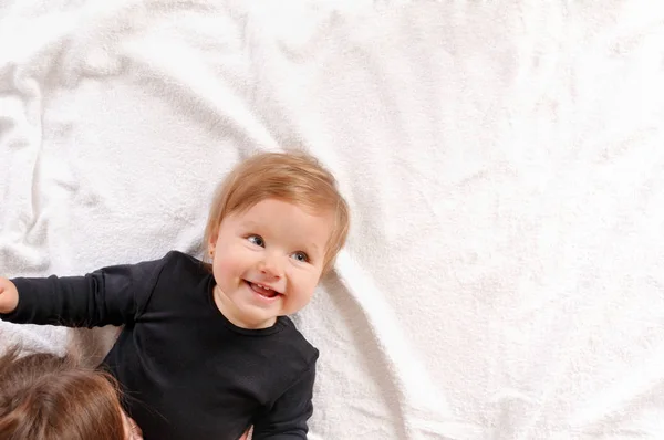 Retrato de la hermosa mamá jugando con su bebé en el dormitorio — Foto de Stock