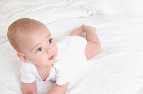 Feliz bebé riendo relajarse en la cama . — Foto de Stock