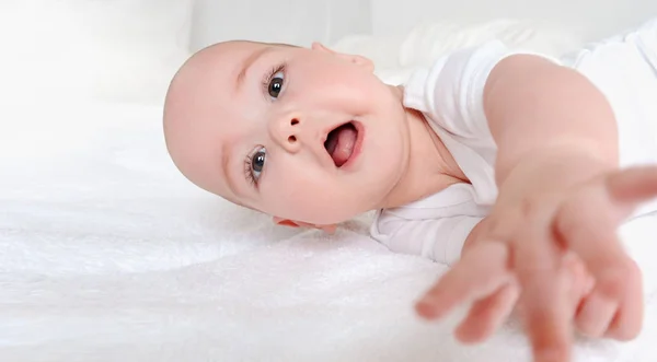 Feliz bebê rindo relaxar na cama — Fotografia de Stock