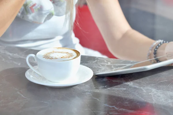 Женщина пользуется сенсорным экраном, стоя в кафе — стоковое фото